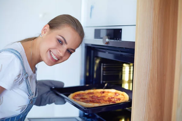 Feliz joven cocinando pizza en casa — Foto de Stock
