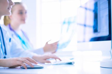 Kadın doktorlar hastanede röntgen görüntülerini inceliyor ve tartışıyorlar..