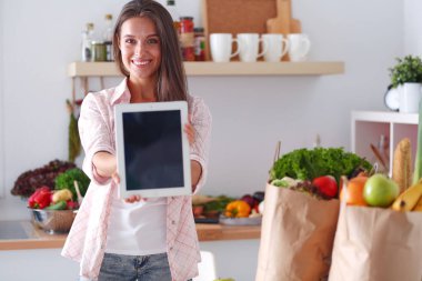Mutfakta ipad 'ini kullanan genç bir kadın. Genç kadın.