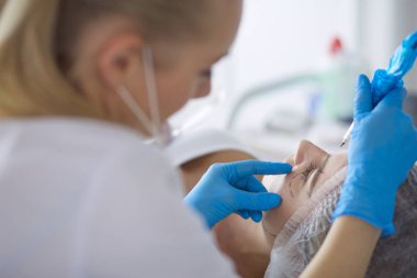 Kaşlar için kalıcı makyaj. Güzellik salonunda kalın kaşlı güzel bir kadın.