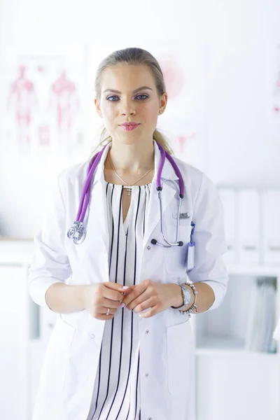 Médico sonriente con un estetoscopio médico de pie uniforme —  Fotos de Stock