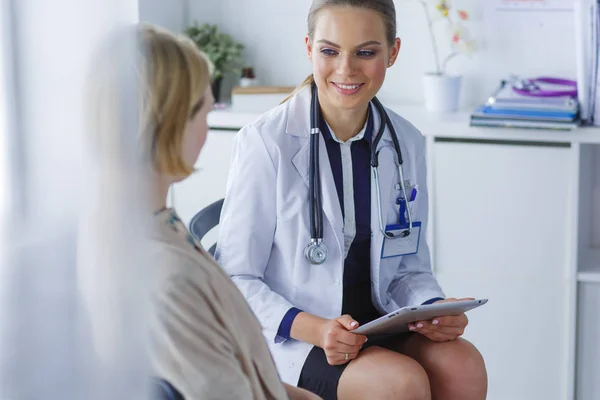 Doctor y paciente discutiendo algo mientras están sentados en la mesa. Concepto de medicina y salud — Foto de Stock