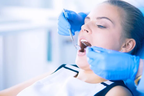 Mujer joven con la boca abierta examinando la inspección dental en el consultorio del dentista. — Foto de Stock