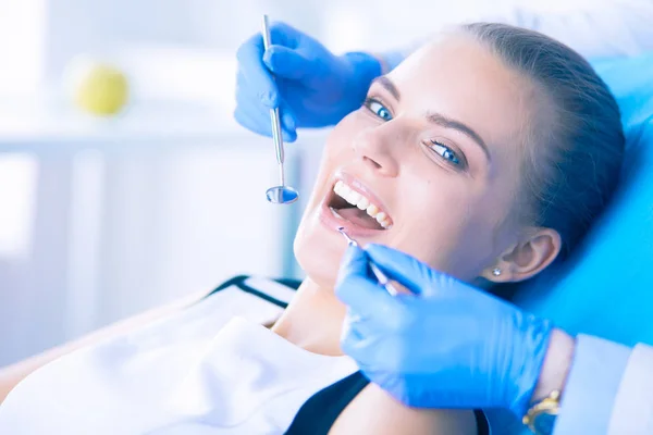 Mujer joven con la boca abierta examinando la inspección dental en el consultorio del dentista. — Foto de Stock