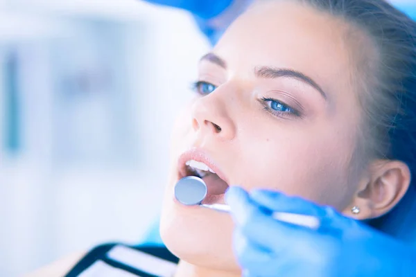 Mujer joven con la boca abierta examinando la inspección dental en el consultorio del dentista. — Foto de Stock