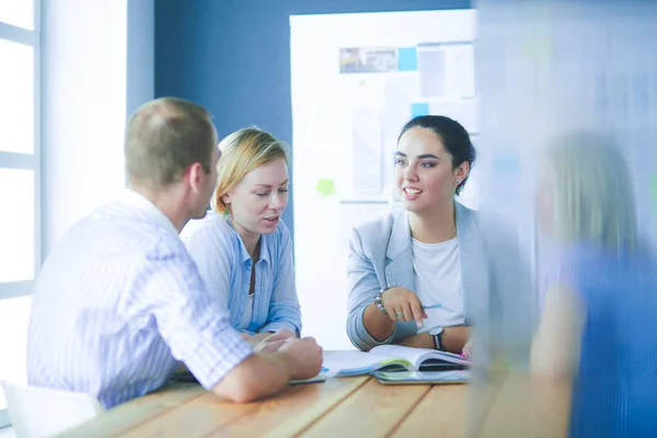 Jongeren studeren met boeken op hun bureau. Mooie vrouwen en mannen die samenwerken. — Stockfoto