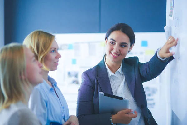 Concepto de negocio, educación y oficina - equipo de negocios con flip board en la oficina discutiendo algo. — Foto de Stock