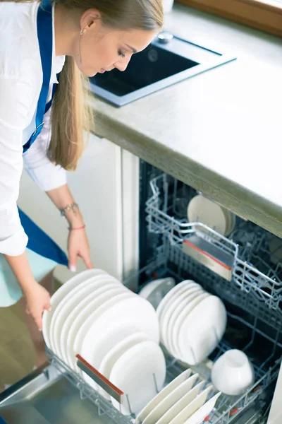 Dishwasher. Young woman in the Kitchen doing Housework. Wash-up