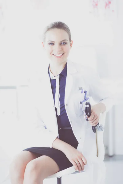 Retrato de uma jovem médica sentada à mesa no hospital — Fotografia de Stock