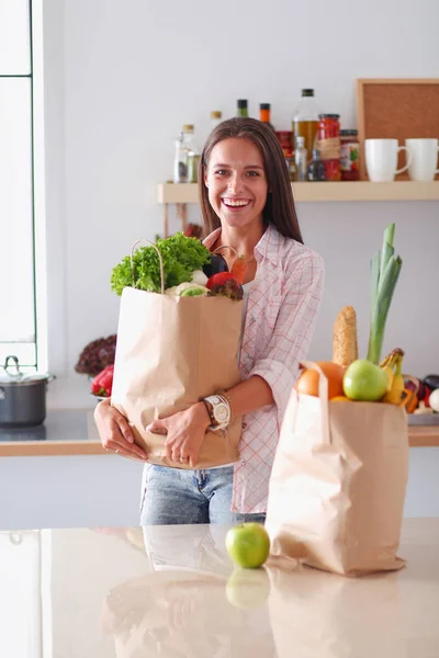Молода жінка тримає продуктовий сумку з овочами. Молода жінка — стокове фото