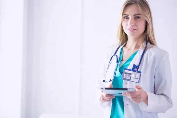 Retrato de una joven doctora, con almohadillas en la mano, en un consultorio médico —  Fotos de Stock