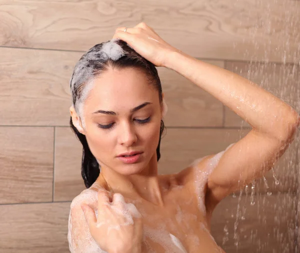 Jonge beautyful vrouw onder de douche in de badkamer. — Stockfoto