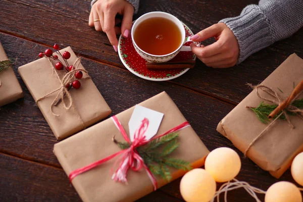 Femme assise sur le bureau avec boîte cadeau de Noël. Mains de femme — Photo