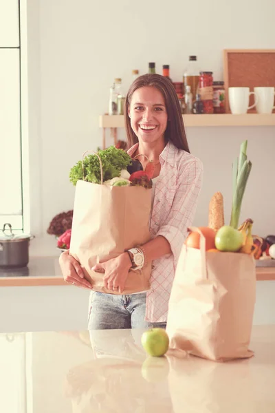 野菜の入った食料品の買い物袋を持っている若い女性。若い女性 — ストック写真