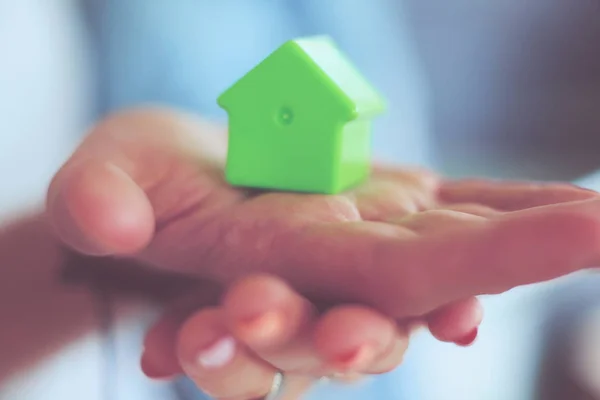 Model huis in handen van een paar, staan in de nieuwe woning. Model huis. — Stockfoto