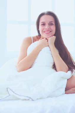 Güzel bir kadın yatağında uzanıyor..