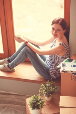 Karton kutularla dolu yeni bir evde bir kadın. Evdeki kadın..