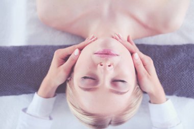 Masaj masasında uzanmış gözleri kapalı rahatlayan genç bir kadın. - Kadın. Spa salonu