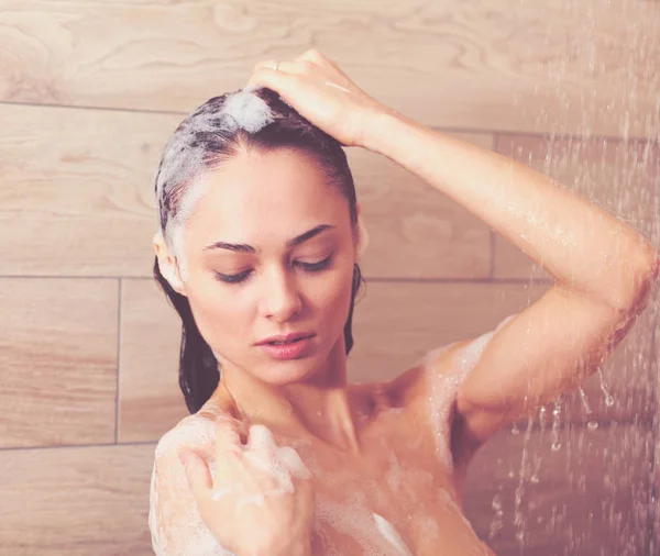 Ung, vakker kvinne under dusjen på badet. . – stockfoto