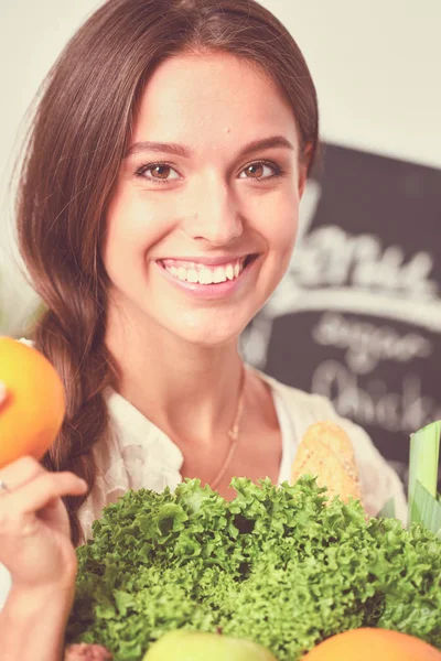 台所に野菜を持った笑顔の若い女性。笑顔の若い女性 — ストック写真