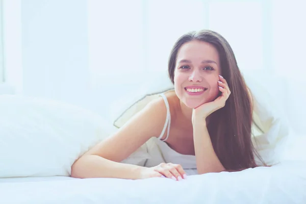 Pretty woman lying down on her bed at home. Stock Photo