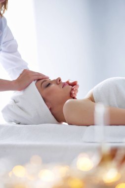 Masaj masasında uzanmış gözleri kapalı rahatlayan genç bir kadın. - Kadın. Spa salonu