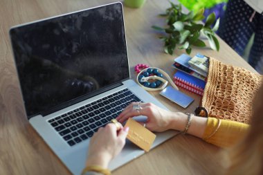 Genç bir kadın kahve molasında ya da kahve molasında dizüstü bilgisayar kullanıyor..