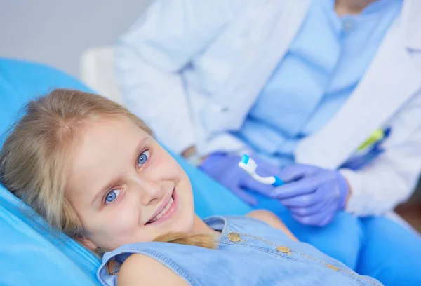 Niña sentada en el consultorio de dentistas. — Foto de Stock