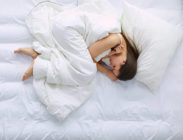 Junge Frau empfindet Schmerzen im Bett. — Stockfoto