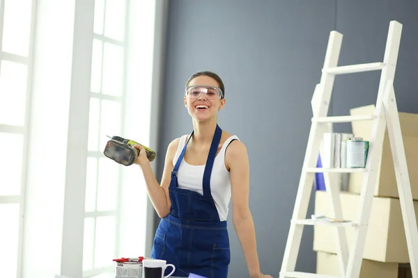 Donna operaia con trapano in piedi in nuova casa . — Foto Stock