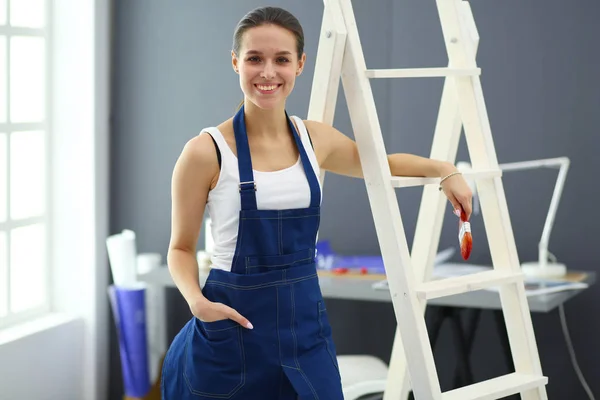 Donna operaia con trapano in piedi in nuova casa . — Foto Stock