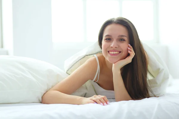 Pretty woman lying down on her bed at home. Stock Photo