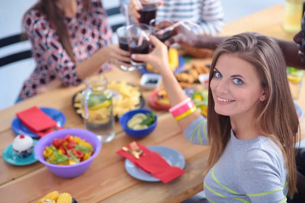 Draufsicht auf eine Gruppe von Menschen beim gemeinsamen Abendessen, während sie am Holztisch sitzen. Essen auf dem Tisch. Die Menschen essen Fast Food. Porträt eines Mädchens — Stockfoto