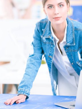 Masanın yanında duran iki genç kadın enstrüman, plan ve dizüstü bilgisayarla.