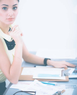 Stüdyoda çalışan genç bir moda tasarımcısı.