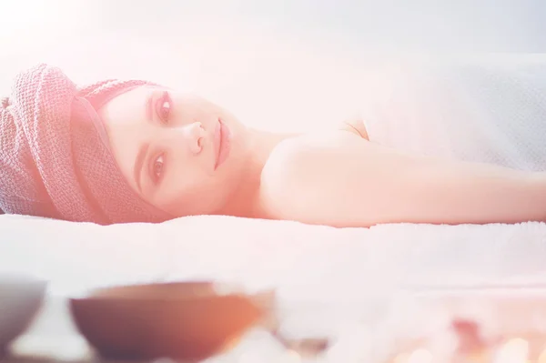 Jovem deitada em uma mesa de massagem, relaxando com os olhos fechados. Mulher. Salão de Spa — Fotografia de Stock