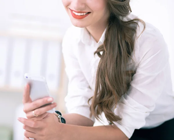 Empresária enviando mensagem com smartphone no escritório — Fotografia de Stock