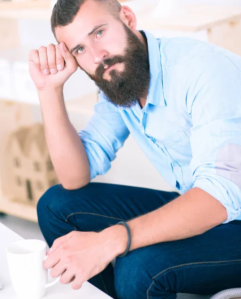 Young businessman sitting on chair in office — Stock Photo, Image