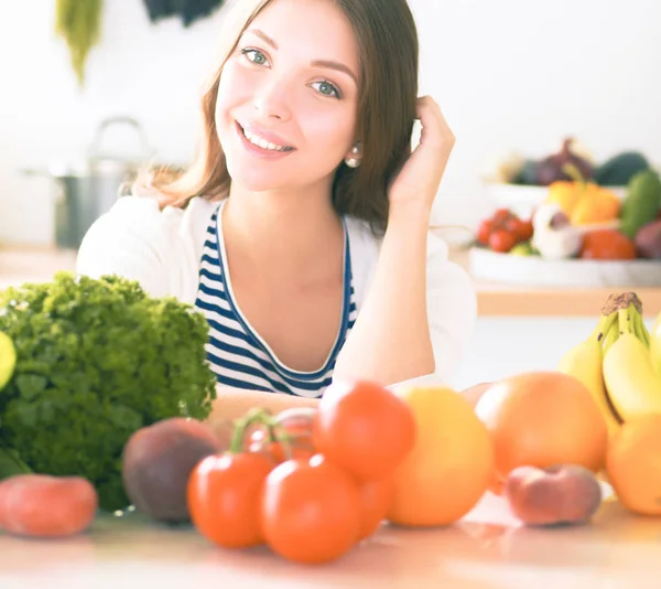 Jonge vrouw in de buurt van bureau in de keuken — Stockfoto