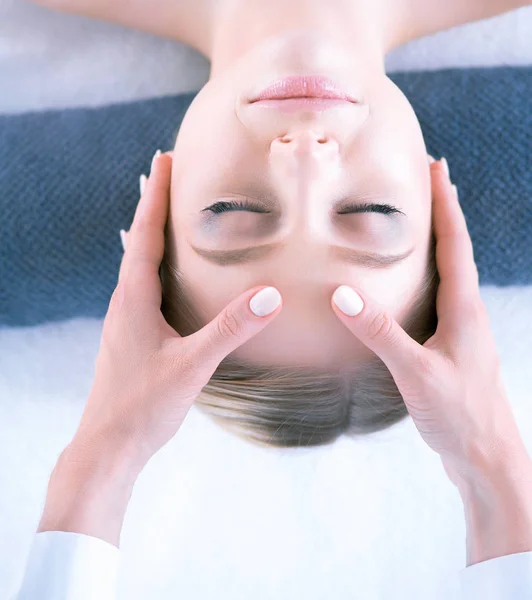 Mujer joven acostada en una mesa de masaje, relajándose con los ojos cerrados. Una mujer. Salón de spa — Foto de Stock