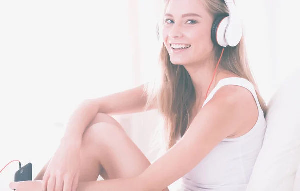 Portrait of beautiful woman in morning listening music sitting on bed at home — Stock Photo, Image