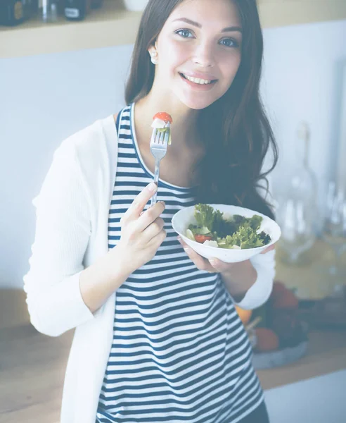 Genç bayan mutfakta masanın yanında oturuyor.