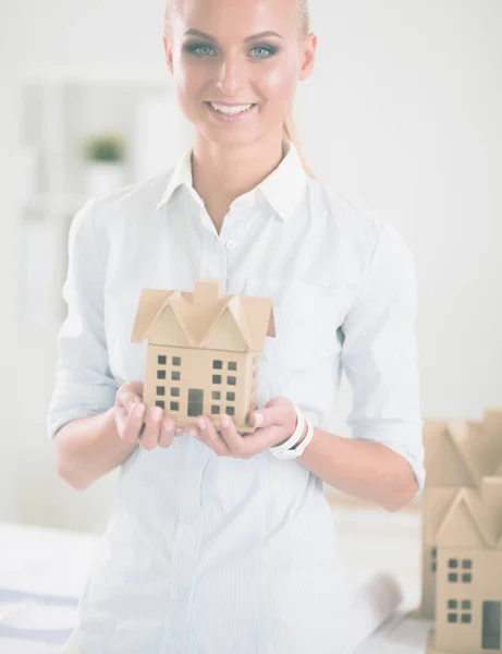 Portrait of female architect with blueprints at desk in office — Stock Photo, Image