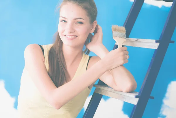 Felice bella giovane donna che fa pittura murale, in piedi vicino alla scala — Foto Stock