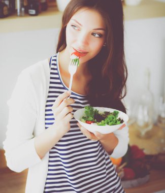 Salata yemek ve karışık salata tutan genç kadın