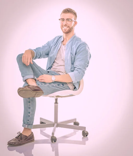 Fiatal ember ül a széken, elszigetelt fehér háttér felett. Startupper. Fiatal vállalkozó. — Stock Fotó