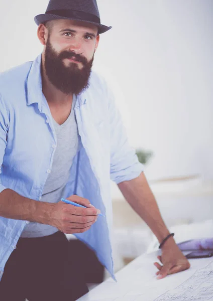 Retrato de diseñador masculino en sombrero con planos en el escritorio —  Fotos de Stock