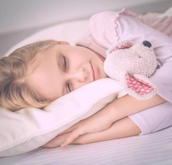 儿童小女孩睡在床上有一只玩具泰迪熊 — 图库照片