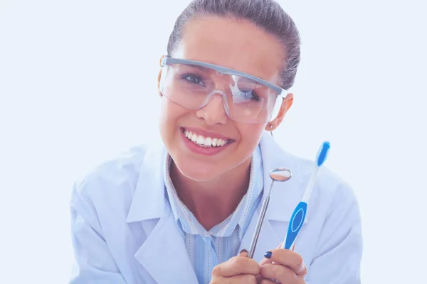 Schöne Zahnärztin, die eine Zahnbürste auf weißem Hintergrund hält und zeigt. Zahnarzt — Stockfoto
