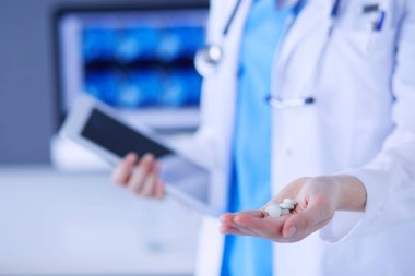 Doktorların ellerinde haplar ve tablet tutarken yakın plan çekimleri..